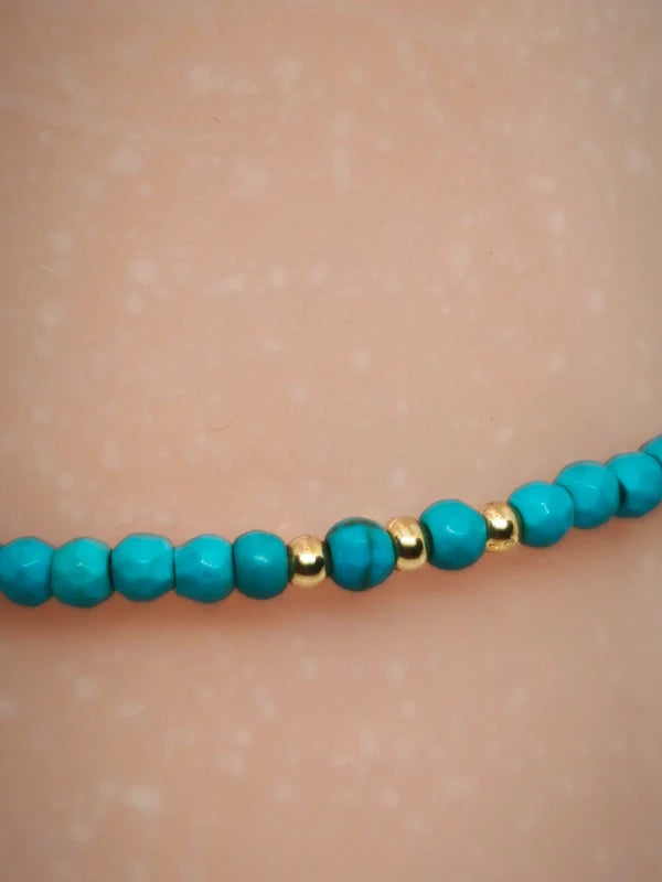 Bracelet en perles facettées d'howlite turquoise.